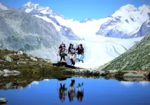 Wandelaars op een bergpad met uitzicht op de Aletschgletsjer in het Wallis