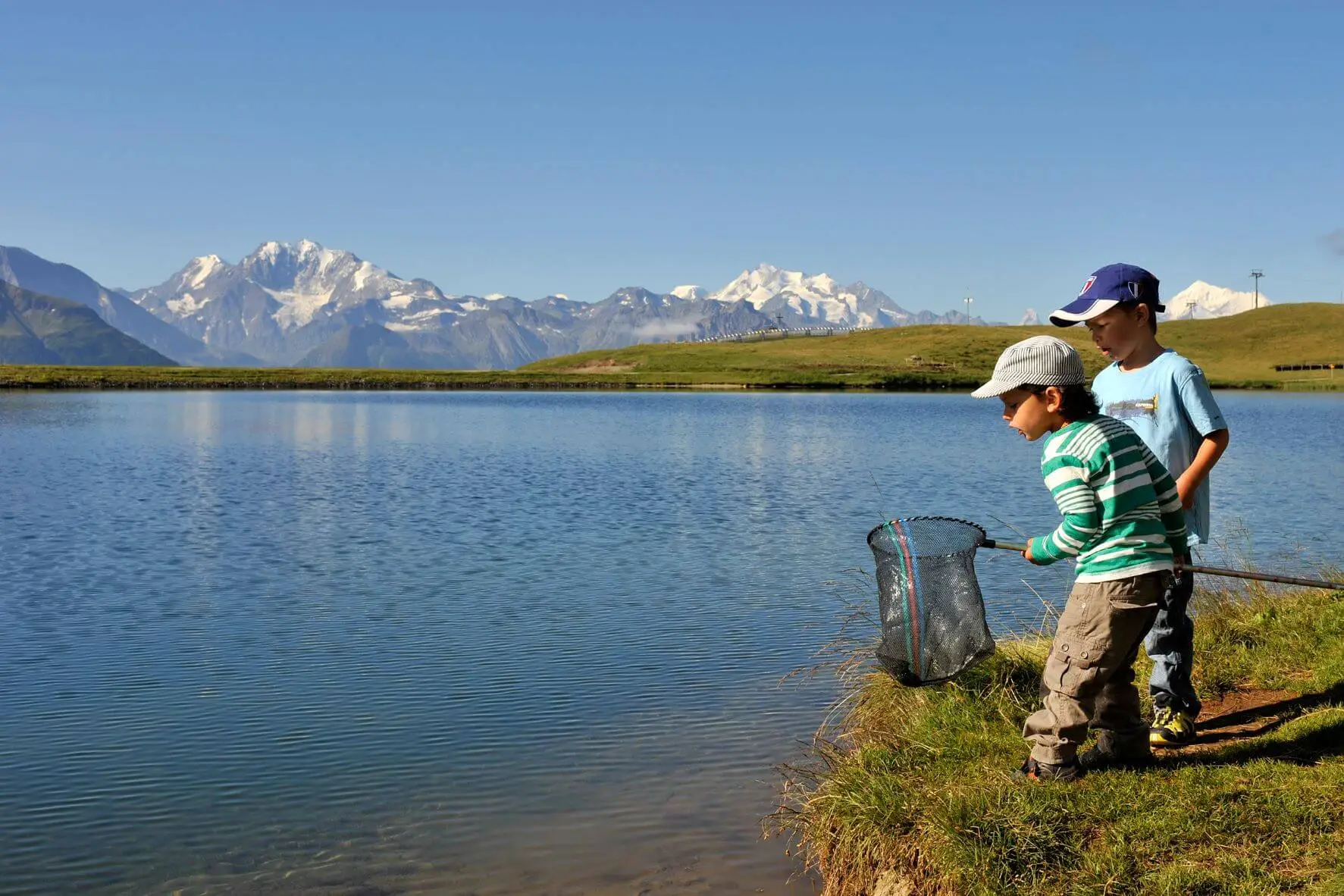 Kinderen spelen aan de Bettmersee, een bergmeer in de Aletsch Arena, Wallis